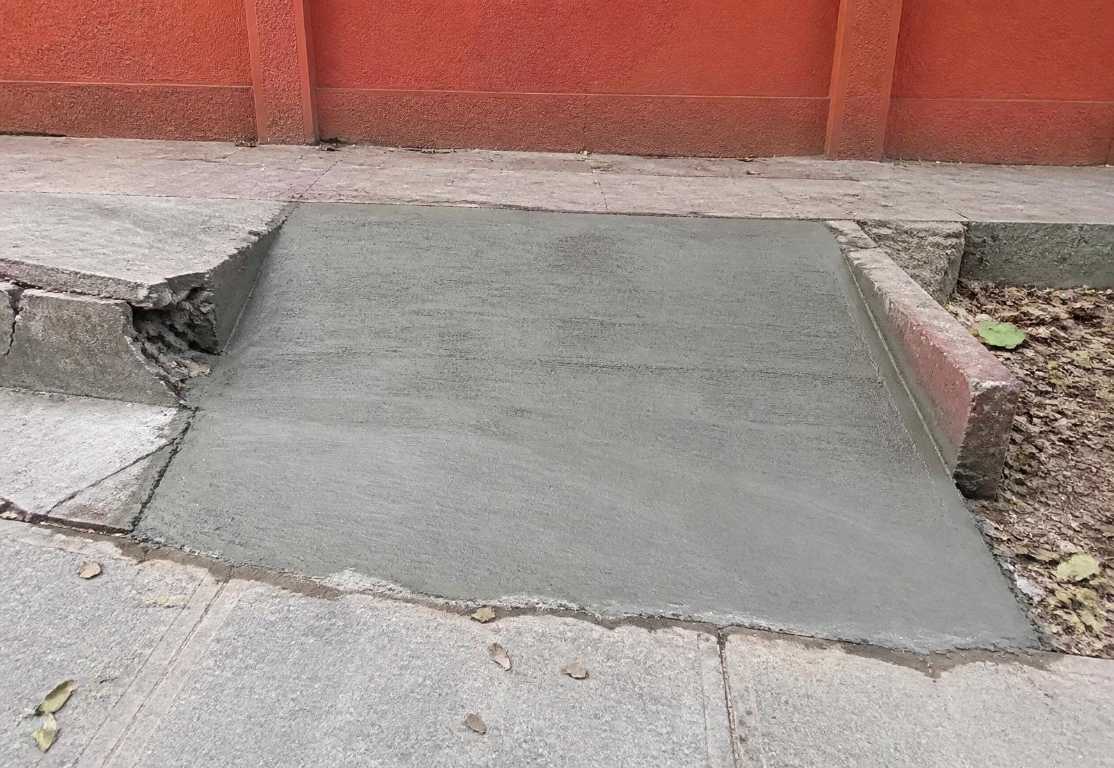A newly poured concrete wheelchair ramp in a broken Koramangala footpath